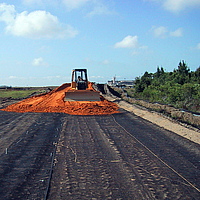 Bulldozer espalha areia sobre uma geogrelha Basetrac Grid colocada para reforço da camada de base num estaleiro de construção