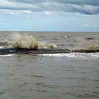 Groynes e quebra-mares no mar com ondas para proteção da costa