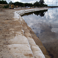 Grande plano dos sacos SoilTain como proteção costeira na margem do lago