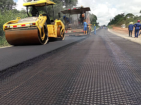 O asfalto é aplicado com uma máquina de alcatrão e depois compactado com um rolo na HaTelit G