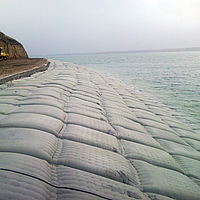 Sacos de areia à beira da água para proteção das margens