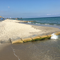 Sacos SoilTain na costa de uma praia turística de areia