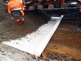 Instalação de geossintéticos na subestrutura do leito da pista para reforçar a estabilização da camada de base