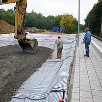 Escavadora coloca balastro sobre Basetrac® Duo-C