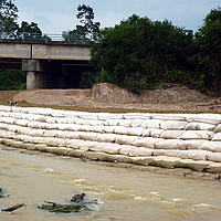 Sacos de areia na margem do rio para proteção das margens