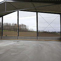 Vista interior de redes de proteção contra o vento que cobrem a frente de um armazém.