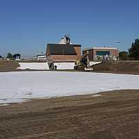 O tapete de bentonite Tektoseal® Clay é parcialmente coberto com terra após a instalação