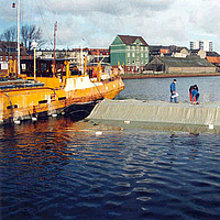 Trabalhadores instalam materiais geotêxteis para proteção do fundo do porto