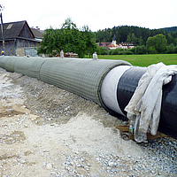 Os trabalhadores enchem a cobertura do oleoduto Incomat® com betão